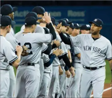  ?? NATHAN DENETTE — THE CANADIAN PRESS VIA AP, FILE ?? Yankees center fielder Aaron Hicks, right, high-fives teammates as the Yankees and Blue Jays are introduced at an opening day game in Toronto. The percentage of black players from the United States and Canada on opening-day active rosters has risen to...