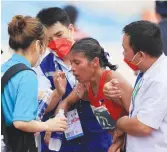  ?? ?? MEDICAL PERSONNEL attend to marathoner Christine Hallasgo after she suffered cramps in the final stretch of the 42-kilometer footrace yesterday. (PSC-POC Media)