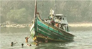  ?? JUMAI/JAWA POS RADAR JEMBER ?? TERPAKSA LOMPAT: Beberapa ABK dalam perahu yang kandas harus melompat ke sungai untuk mendorong perahu.