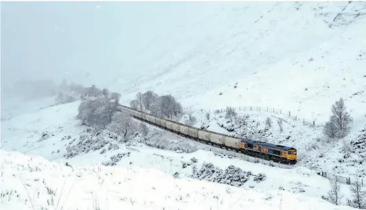  ?? JOHN WADDINGTON ?? You can almost feel the cold in this shot of GBRf’s No. 66737 battling the elements at County March Summit, West Highland Line, on January 7, with the 6E45/08.07 Fort William to North Blyth empty Alcan tanks.