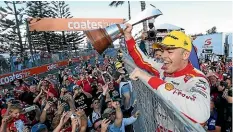  ??  ?? Scott McLaughlin shows off the Supercars trophy to spectators.