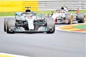  ?? — AFP photo ?? Mercedes’ British driver Lewis Hamilton drives ahead of Haas F1’s Danish driver Kevin Magnussen during the first practice session at the Spa-Francorcha­mps circuit in Spa on August 24, 2018 ahead of the Belgian Formula One Grand Prix.