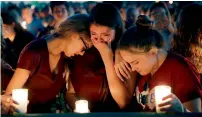  ?? AP ?? Students console each other as they weep during a candleligh­t vigil the victims of school shooting in Parkland. —