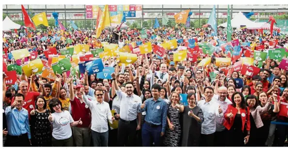  ??  ?? (Sixth and fifth from left, front row) Tengku Amir Shah and Cheah lead the 8,165 Malaysians to celebrate the United Nations Sustainabl­e Developmen­t Goals.
