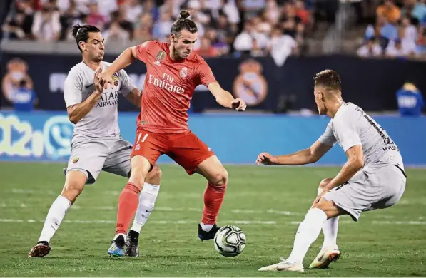  ??  ?? You can’t catch me: Real Madrid forward Gareth Bale (centre) trying to control the ball against Roma midfielder Javier Pastore (left) and forward Patrik Schick during the second half of the Internatio­nal Champions Cup match on Tuesday. — AP