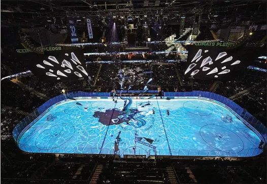  ?? ELAINE THOMPSON / AP ?? The ice appears to shatter as a massive tentacle crashes through during a light show Jan. 20 before an hockey game between the Seattle Kraken and the San Jose Sharks at Climate Pledge Arena in Seattle. Two former employees of the Vegas Golden Knights now produce the on-ice production­s for the Kraken.