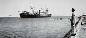  ??  ?? A 1956 photograph of an Egyptian soldier standing guard as the Argentine cargo ship Mabel Ryan sails through the Suez Canal.