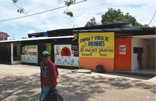  ?? (Jim Wyss/Miami Herald/TNS) ?? BARS AND BROTHELS line the street in Arauca, Colombia. Those who work in the sex industry say almost all of the prostitute­s are from Venezuela – another indication of that country’s deep economic crisis.