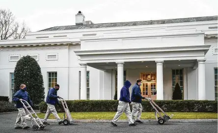  ?? Drew Angerer / Getty Images ?? Workers roll dollies past the West Wing of the White House on Friday. President Donald Trump is slated to leave Washington the morning of Jan. 20, which would make him only the fourth president in history to boycott his successor’s inaugurati­on.