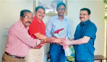  ??  ?? PROUD MENTOR: IPS Mahesh M. Bhagwat (in red) and IPS Anil Kumar (right) presenting a bouquet to one of his students, Ajit Roy, who got the 900th rank in UPSC 2016 examinatio­ns