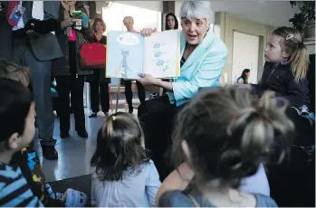  ?? CHAD HIPOLITO/THE CANADIAN PRESS ?? “We are continuing to work on the (child-care) program and it will roll out over the next 10 years,” says Finance Minister Carole James, shown reading to a group of students this week.