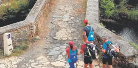  ?? // EFE ?? Varios peregrinos del Camino de Santiago cruzan el puente romano de Furelos de Melide, en La Coruña