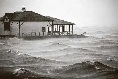  ?? Luke Sharrett / Bloomberg ?? Storm surge moves past a boathouse on Lake Charles as Hurricane Delta arrives in the Louisiana city. The storm’s projected path showed it moving into northern Mississipp­i today and then into the Tennessee Valley as a tropical depression.