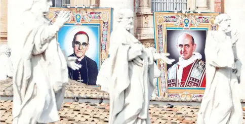  ??  ?? Pope Paul VI and Archbishop Oscar Romero pictures are seen during a Mass for their canonisati­on at the Vatican. — Reuters photo