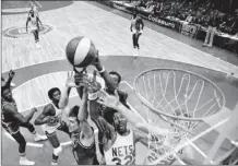  ?? AP file photo ?? Denver Nuggets’ Bobby Jones, (second left), New York Nets’ Julius Erving (fourth left) and Jim Eakins (right) battle for a rebound during the ABA championsh­ip playoff game at the Nassau Coliseum on May 14, 1976. The Denver Nuggets are the last of the four ABA teams that merged with the NBA to reach the Finals and is stirring up fond memories of the defunct league.