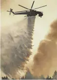  ?? FOTO: ANGELOS TZORTZINIS / DPA ?? Ein Hubschraub­er wirft Wasser über einem Waldbrand ab.