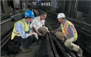  ?? RICHARD DREW— ASSOCIATED PRESS ?? ConEd CEO John McAvoy, left, New York Gov. Andrew Cuomo, center, and WSP USA Senior Vice President Charlie Hall, look at tracks in the Columbus Circle subway staion interlocki­ng, during a media tour, in New York, Wednesday, Aug. 9, 2017. Cuomo on...