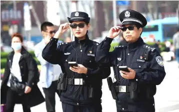  ??  ?? Police officers display their AI-powered smart glasses in Luoyang, Henan province, China. — Reuters