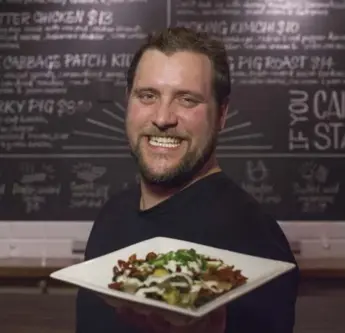  ?? PAWEL DWULIT PHOTOS/TORONTO STAR ?? Adam Dolley, chef and co-owner of Loaded Pierogi, with the Cabbage Patch Kid — eight perogies topped with deep-fried Brussels sprouts, sun-dried tomatoes and ranch dressing.