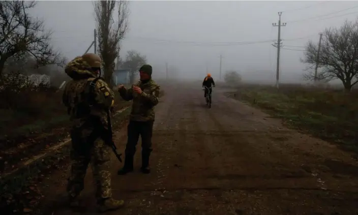  ?? Photograph: Valentyn Ogirenko/Reuters ?? A Ukrainian serviceman and a chaplain have a discussion on a road near Shihurivka.