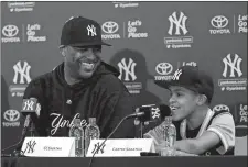  ?? LYNNE SLADKY/AP PHOTO ?? Yankees pitcher CC Sabathia listens as his son Carter responds to a question during a news conference on Saturday in Tampa, Fla.