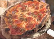  ?? LAUREN DELGADO/ ORLANDO SENTINEL ?? A wood-fired oven cranks out Neapolitan pizzas such as this due carni with sausage and pepperoni over top.