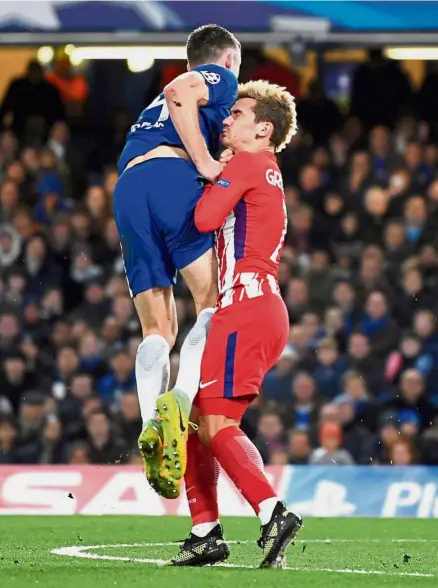  ?? — Reuters ?? Ouch!: Atletico Madrid’s Antoine Griezmann colliding with Chelsea’s Gary Cahill during the Champions League match on Tuesday.