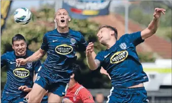  ??  ?? Everyone up: City’s John Irving, centre, goes high for the ball during an intense competitio­n.