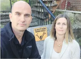  ??  ?? Ross and Erin Storey are paying a mortgage on a house they can't set foot in after a sinkhole opened up in their front yard in Sechelt.