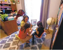  ?? NELVIN C. CEPEDA U-T ?? Maggie Tamayo works with her daughters Amelia and Esperanza on their homeschool assignment­s. Tamayo said distance learning didn’t work for their family.