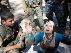  ??  ?? A civilian prays after she was rescued by SDF fighters from the city’s stadium during the battle for the city (Reuters)