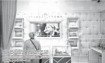  ??  ?? A visitor looks at jewellery displayed in the window of the Ivanka Trump Collection store at Trump Tower in June 2017. The brand was founded in 2014 and later became politicise­d for offshore manufactur­ing and working conditions. — WPBloomber­g photo by Michael Nagle