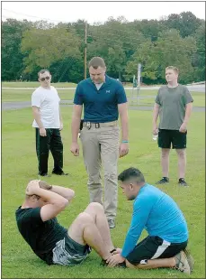  ?? Keith Bryant/The Weekly Vista ?? Police department applicant Marshall Hill, left, does sit-ups with support from fellow applicant Joshua Loya while Lt. Scott Vanatta monitors.