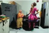  ??  ?? Clowns Gabor Hrisafis, left, and Beth Walters talk in a hallway of the Dunkin Donuts center before a performanc­e.