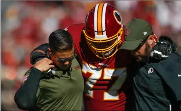  ??  ?? In thisSunday Washington Redskins offensive guard Shawn Lauvao (77) is helped off the field after an injury during the first half of an NFL football game between the Atlanta Falcons and the Washington Redskins, in Landover, Md.AP PhoTo/PAblo MArTINez MoNsIVAIs