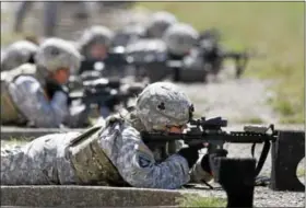  ?? AP Photo ?? In this Sept. 18, 2012, file photo, female soldiers from 1st Brigade Combat Team, 101st Airborne Division train on a firing range while testing new body armor in Fort Campbell, Ky., in preparatio­n for their deployment to Afghanista­n. Women may be able to begin training as Army Rangers by mid-2015, and as 1avy SEALs a year later under broad plans Defense Secretary Chuck Hagel is approving that would slowly bring women into thousands of combat jobs.