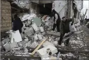  ?? ROMAN HRYTSYNA — THE ASSOCIATED PRESS ?? People check a destroyed house in Hlevakha in the Kyiv region of Ukraine on Thursday following a Russian attack.