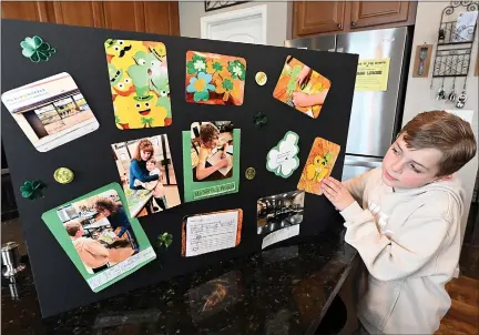  ?? JENNY SPARKS — LOVELAND REPORTER-HERALD ?? Oliver Meyers, 8, shows the poster board he made illustrati­ng the St. Patrick’s Day crafts he made for Meals on Wheels Thursday at his home in Loveland. Meals on Wheels drivers delivered the crafts to clients with their meals to make their holiday brighter.
