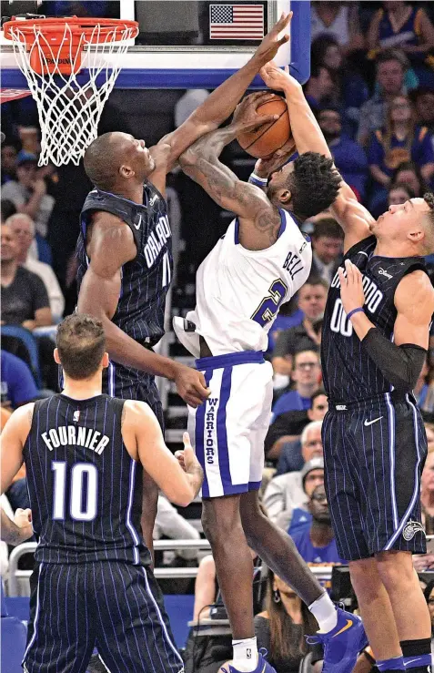  ?? ASSOCIATED PRESS ?? Orlando Magic center Bismack Biyombo and forward Aaron Gordon block a shot by Golden State Warriors forward Jordan Bell as Magic guard Evan Fournier watches during the first half of an NBA basketball game in Orlando, Fla.