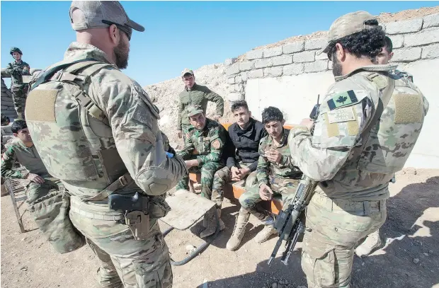 ?? RYAN REMIORZ / THE CANADIAN PRESS ?? Canadian special forces soldiers, left and right, speak with Peshmerga fighters at an observatio­n post Monday in northern Iraq.