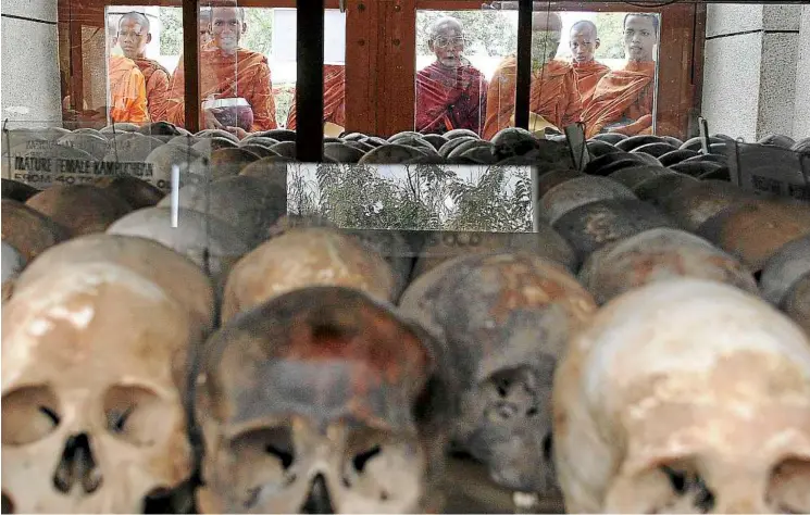  ??  ?? Gruesome reminders: Buddhist monks praying for the dead at the Choeung Ek killing fields memorial, some 15km south-west of Phnom Penh, Cambodia. as many as two million people died from starvation, overwork or execution during the 1975-79 rule of the...