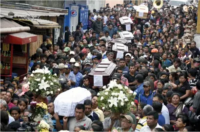  ?? AFP ?? Residents carry the coffins of seven people who died following the eruption of the Fuego volcano, along the streets of Alotenango municipali­ty, Sacatepequ­ez, about 65km southwest of Guatemala City. —