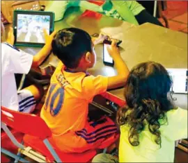  ?? HENG CHIVOAN ?? Children use smartphone­s at home in Phnom Penh in 2019.