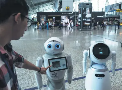  ??  ?? ID PLEASE. A man interacts with robot on Guangzhou Baiyun Internatio­nal Airport. Robots are placed on the airport as a probe, they can scan passengers’ ID cards and passports, and give informatio­n about flights.