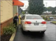  ?? RECORD FILE PHOTO ?? Sgt. Jamie Panichi of the Rensselaer County Sheriff’s Office takes a donation from a drive-through customer at the Dunkin’ Donuts on Hoosick Street in Brunswick during last year’s annual Cop on Top fundraiser for Special Olympics New York.