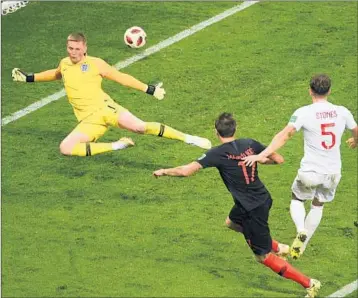  ?? JEWEL SAMAD/GETTY-AFP ?? Mario Mandzukic (17) shoots and scores over England goalie Jordan Pickford to give Croatia a 2-1 victory Wednesday.