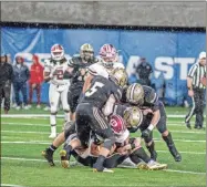  ?? ?? Calhoun senior defensive back Cole Speer and a couple of other Yellow Jackets defenders put the brakes on a Warner Robins runner.