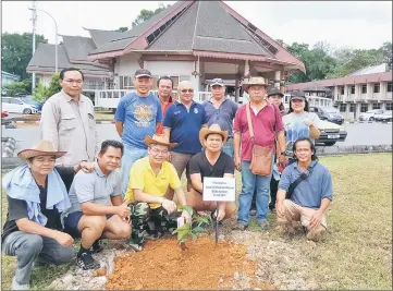  ??  ?? Ik Pahon (fourth left, front row) and the others including Billy (on Ik Pahon’s right) plant a mangosteen sapling on behalf of chief advisor Dato Sri Michael Manyin Jawong.