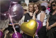  ?? AP file photo ?? People hold a minute of silence in a square in central Manchester, England, on May 25, 2017, after a suicide bombing attack at an Ariana Grande concert at the Manchester Arena.