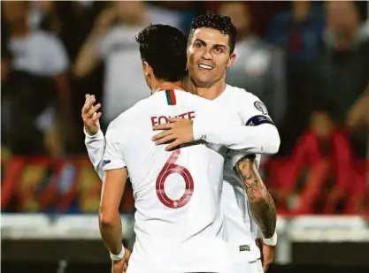  ?? Marko Djurica/reuters ?? Cristiano Ronaldo comemora com o companheir­o José Fonte o seu gol na vitória por 4 a 2 de Portugal sobre a Sérvia, em Belgrado; a seleção lusitana é a atual campeã da Eurocopa e tenta voltar ao torneio